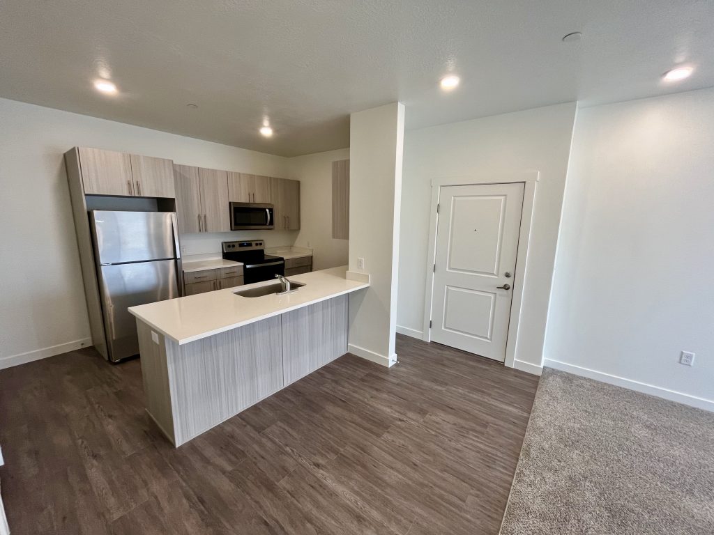 A spacious apartment in Ogden, UT featuring both a modern kitchen and a conveniently stocked refrigerator.